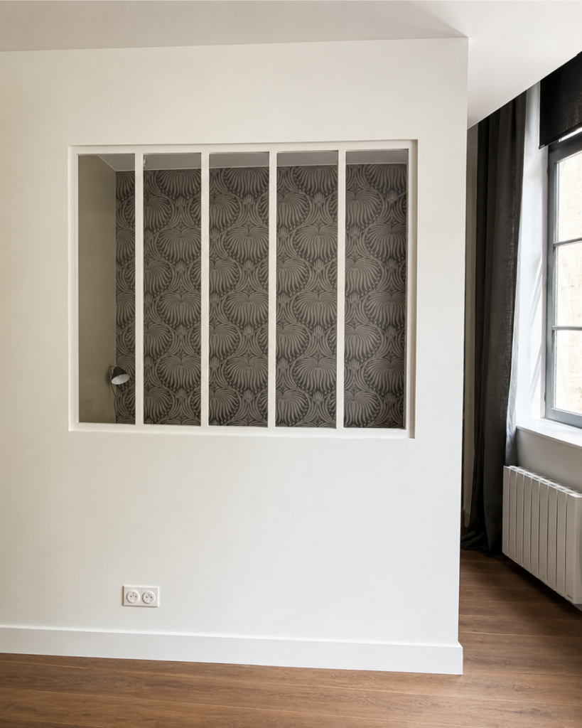 Verrière intérieure avec papier peint décoratif dans un studio rénové à Lille par ADJ Intérieurs.