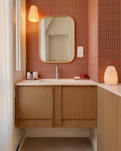 Salle de bain avec carrelage cannelé terracotta, meuble bois clair, miroir arrondi et luminaire en laiton, ADJ Intérieurs Marseille