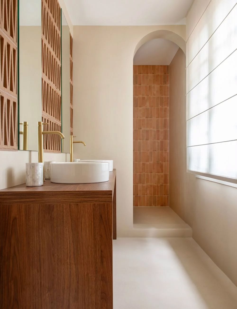 Salle de bain chaleureuse avec meuble vasque en bois, passage en arche et carrelage terracotta — rénovation Marseille, ADJ Intérieurs
